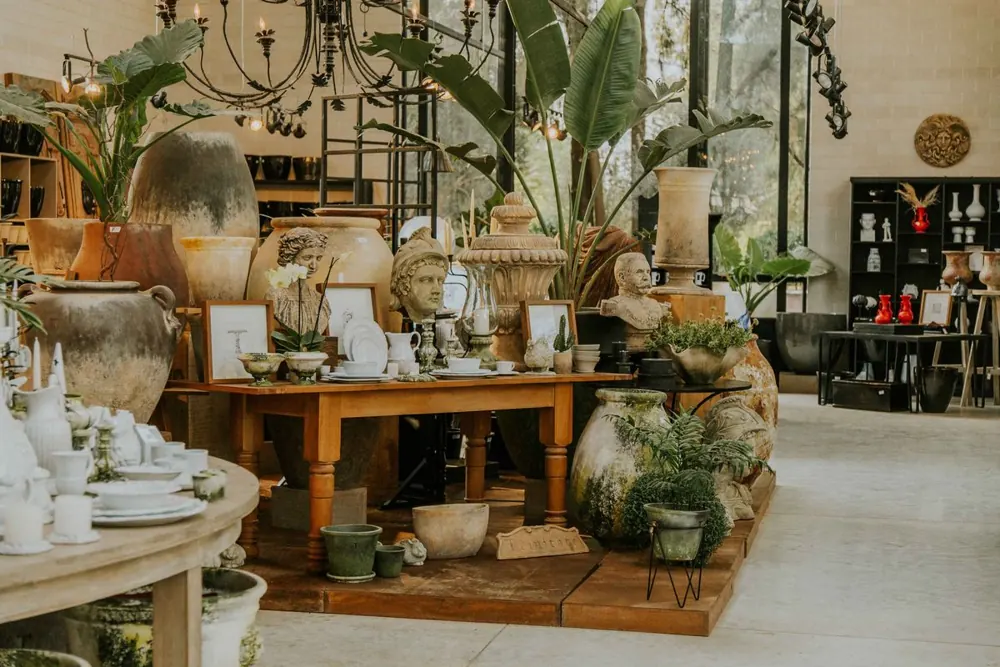 Interior de una tienda con cerámicas, macetas y plantas